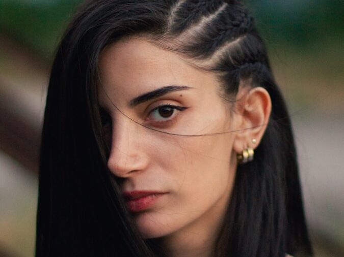 a woman with long black hair wearing a white shirt