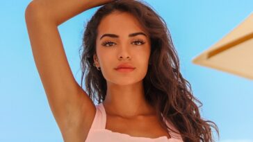 woman in white spaghetti strap top holding her hair