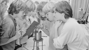 a group of young women standing around a table