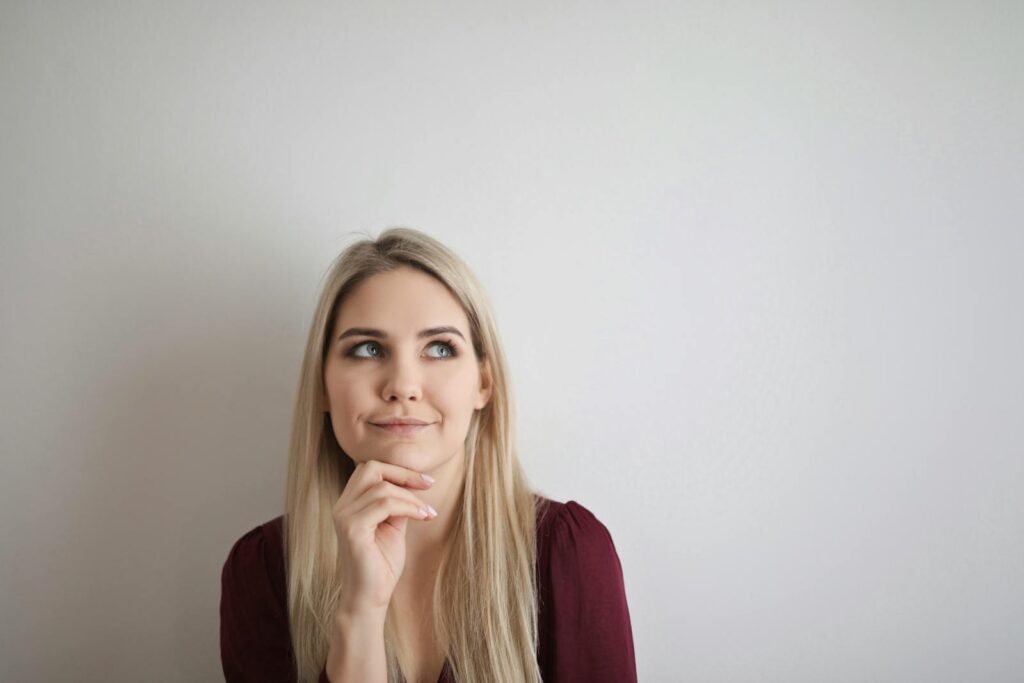 Portrait of a pensive woman with a thoughtful expression against a white background.