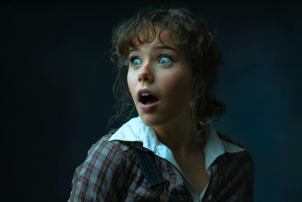 Close-up of a surprised woman in a studio, capturing emotion and expression.