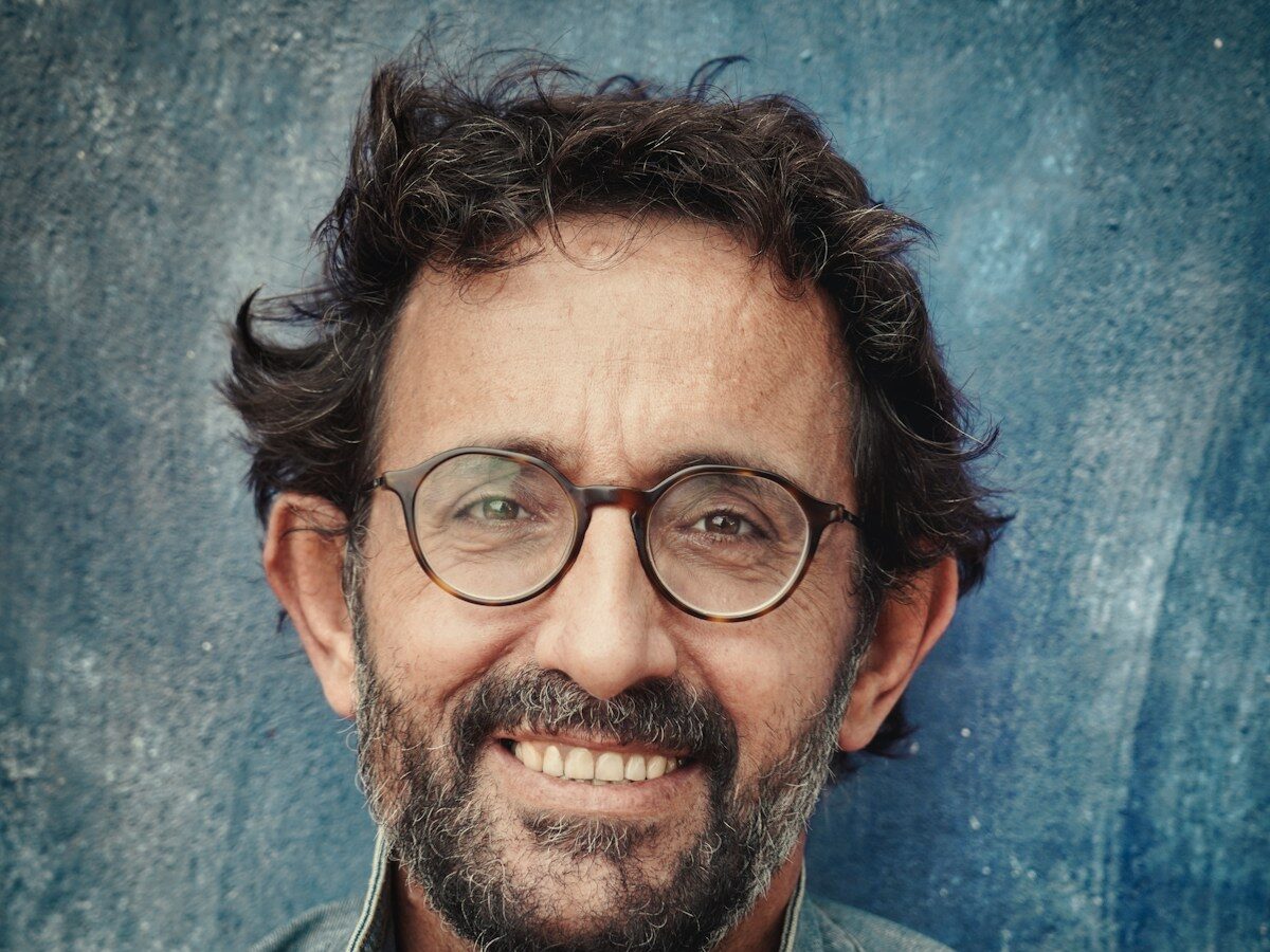 man in gray denim jacket wearing black framed eyeglasses
