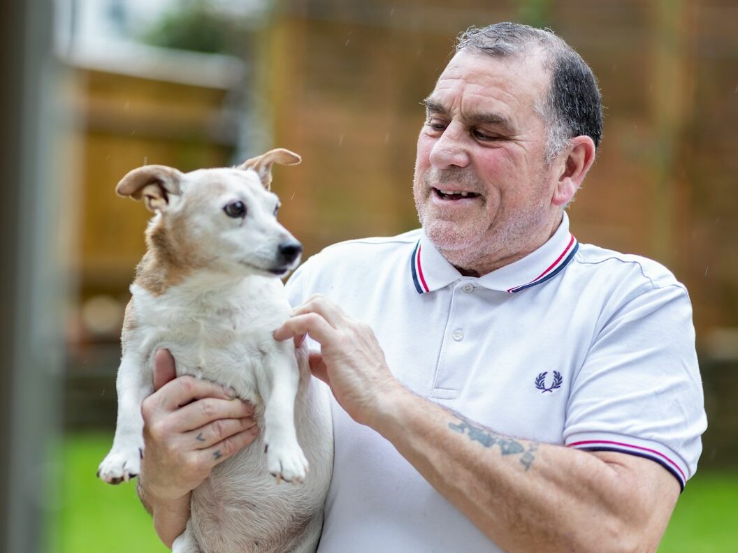 a man holding a small dog in his hands